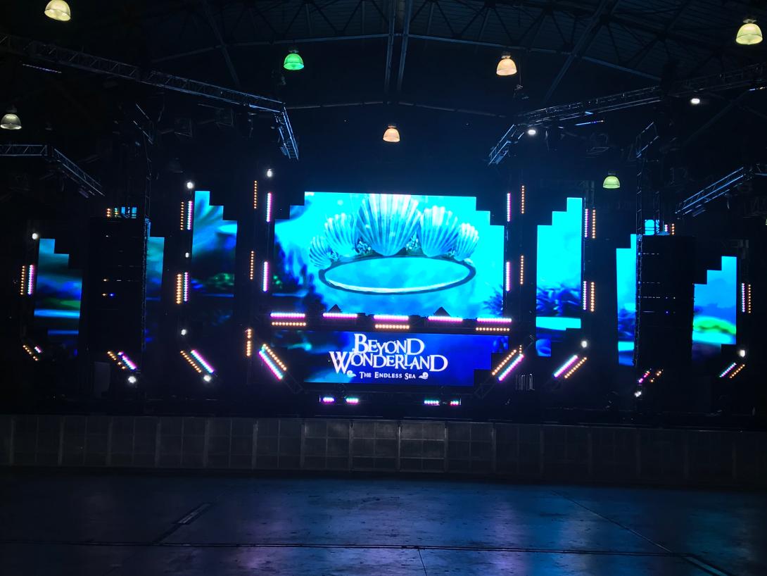 Beyond Wonderland logo and seashells projected on stage in empty concert venue