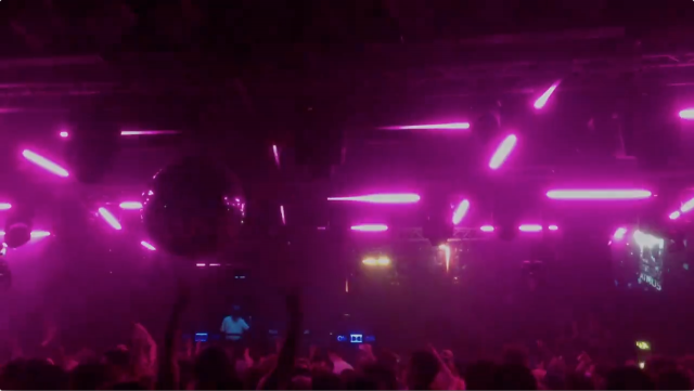A photo of a crowd in a club with purple lighting