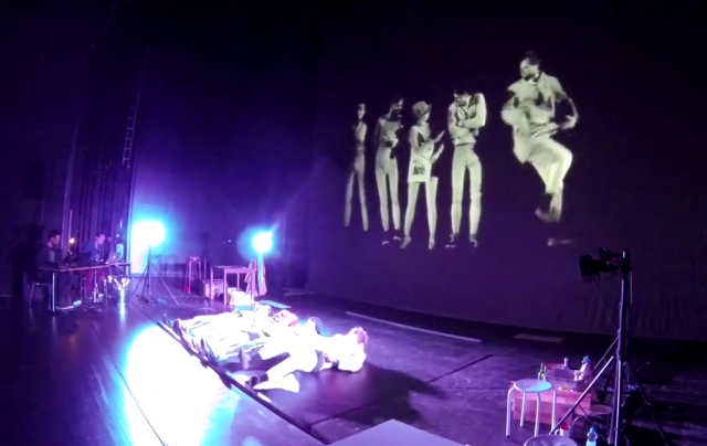 Video still of the actors and stage in "The Floor"